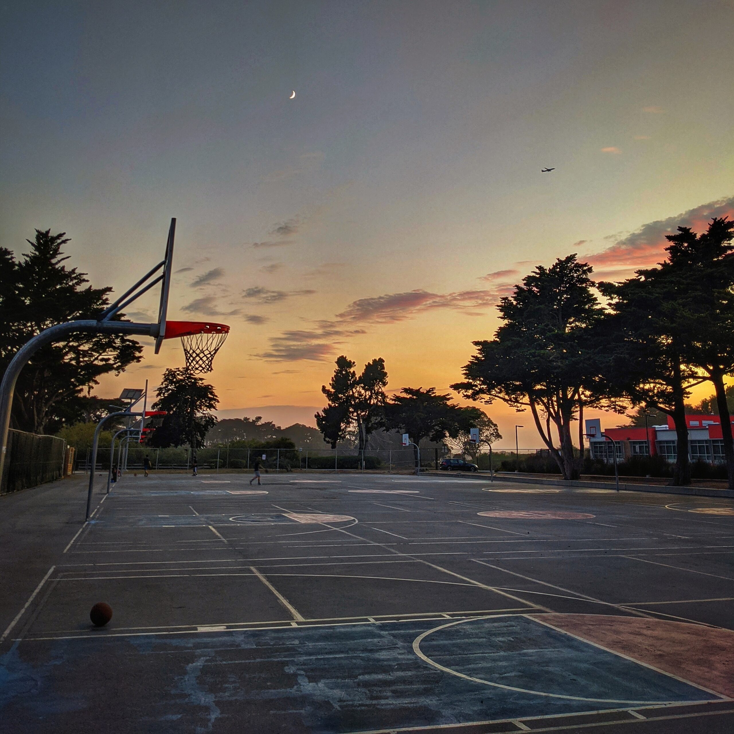 Picture of a basketball court at dusk with a crescent moon visible. #ADHD